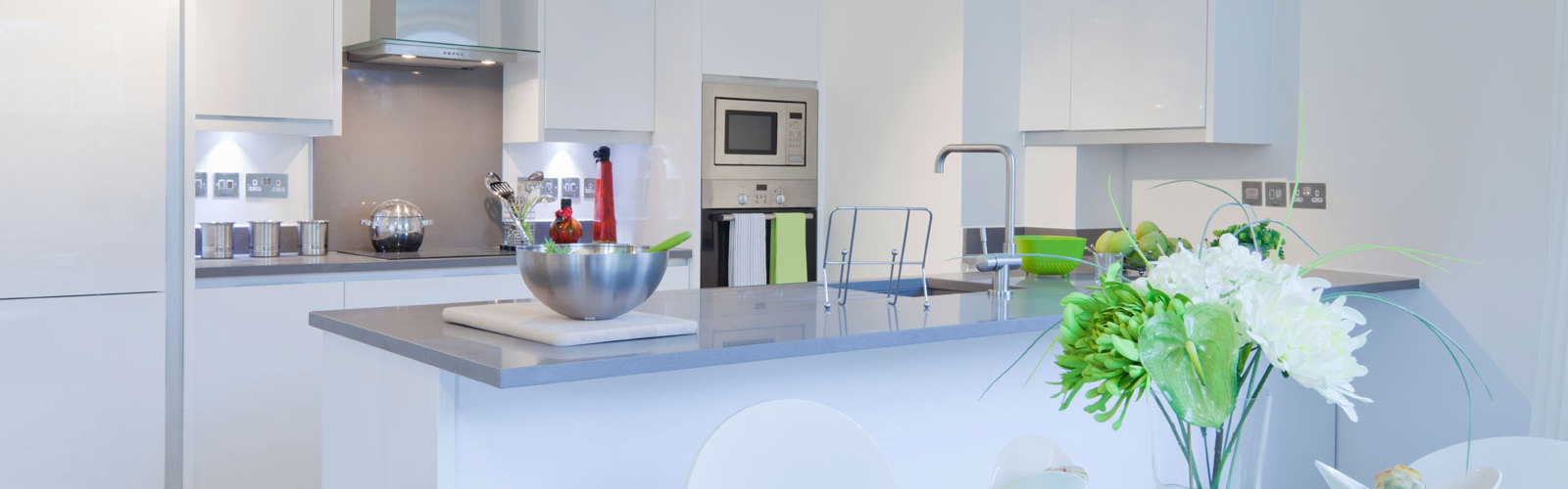 A cleaned kitchen with wine and flowers.